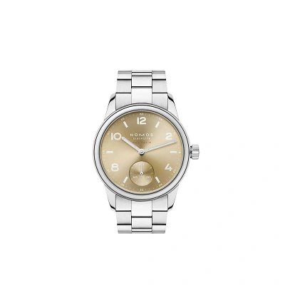 Die NOMOS Glash&uuml;tte Uhr zeigt ein goldenes Zifferblatt mit arabischen Zahlen, kleiner Sekunde und silberfarbenem Edelstahlarmband. Das minimalistische Design wirkt elegant, modern und zeitlos &ndash; ein stilvoller Blickfang f&uuml;rs Handgelenk.