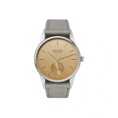 Nomos Orion: Ein schlichtes, elegantes Design mit silberfarbenen Indizes auf dem gold Zifferblatt. Die kleine Sekunde bei 6.
