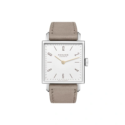 Nomos Tetra mit markant eckigem Design und weissen Zifferblatt mit den goldigen Zeigern. Die braunen Strichindizes und arabische Zahlen sorgen f&uuml;r klare Ablesbarkeit. Das beige veganem Velourslederband rundet den Look ab.
