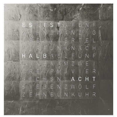 Die QLOCKTWO EARTH 45 in PLATINUM ist in der Front Ansicht. Ein stilvolles Kunstwerk wo jedes Exemplar ist ein Unikat mit handgefertigter Oberfl&auml;che und das ikonische Buchstabenraster, das die Uhrzeit in Worten darstellt.